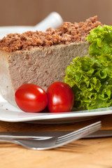 Venison pate on a plate decorated with salad.