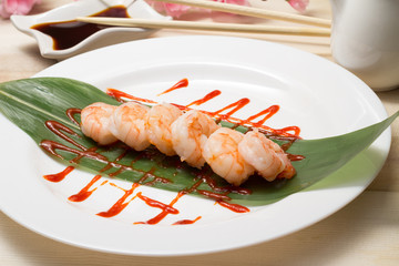 Fried shrimp wirh soy sauce on dish decorated bamboo list