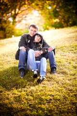 Couple in love sitting on hill on sunset