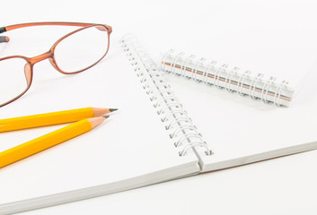 Notebook and yellow pencil and eyeglass