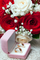 Wedding rings, gift box and flowers for the bride.