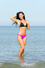 Obraz premium Pretty smiling woman enjoying vacation near the sea