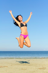 Happy woman jumping at the beach