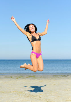 Happy woman jumping at the beach