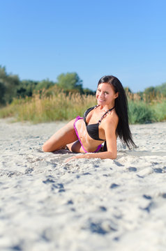 Smiling woman posing on the beach.