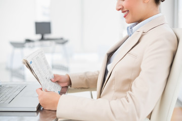 Close up of a pretty businesswoman reading a newspaper