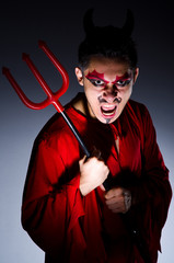 Man in devil costume in halloween concept