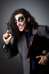 Obraz premium clown with gun and briefcase