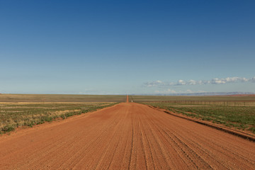 Fototapeta na wymiar endlos gerade Schotterstrasse in Wuestenlandschaft, Namibia