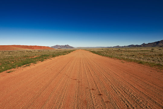 endlos gerade Schotterstra&szlig;e in einer Wuestenlandschaft, Namibia