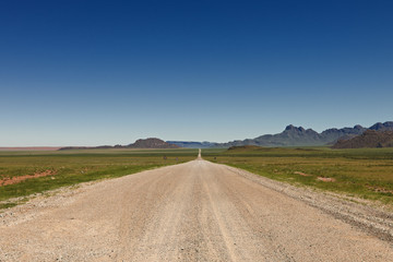 Fototapeta na wymiar nieograniczone prosto żwiru drogowego w krajobraz pustyni w Namibii