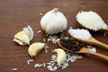 Garlic sea salt  rice grains and black pepper on grunge chopping