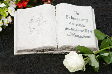 Grab mit Buch aus Stein und Rose