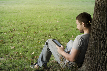 .Young man reading e-book - Powered by Adobe