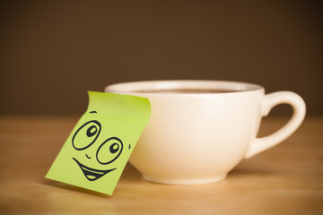 Post-it note with smiley face sticked on cup