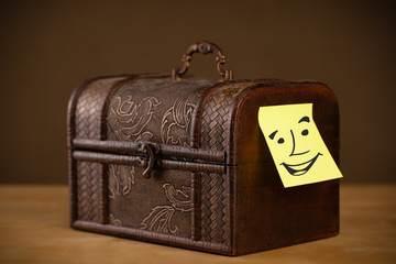 Post-it note with smiley face sticked on a box