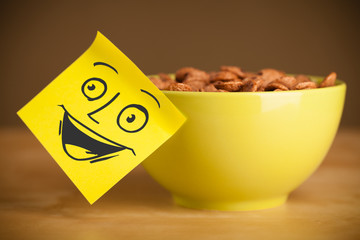 Post-it note with smiley face sticked on a cereal bowl