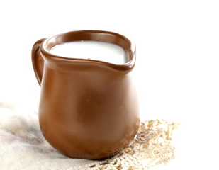 ceramic brown  jug full of milk, rustic style