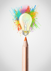 Pencil close-up with colored paint splashes and lightbulb