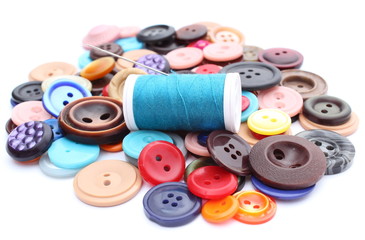 Blue thread with needle and collection of colored sewing buttons