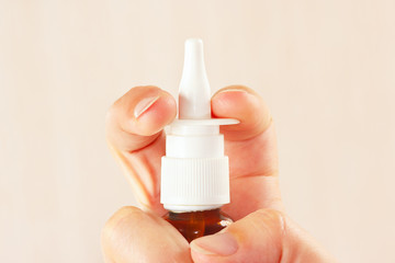 Female hand used a medical nasal spray