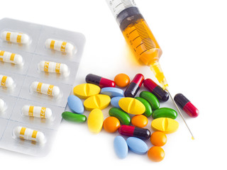 pills capsules and syringe on white background