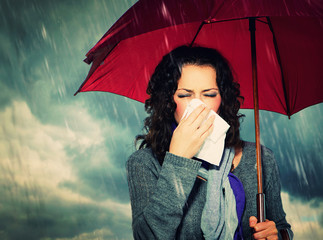 Sneezing Woman with Umbrella over Autumn Rain Background