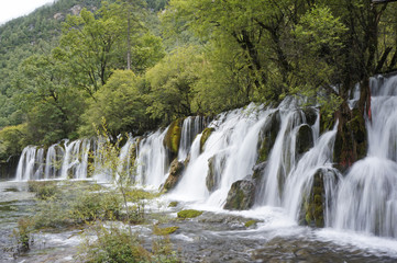 Fototapeta na wymiar Waterfalls among trees