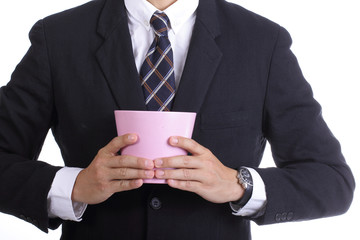 Businessman  holding  pink flowerpot