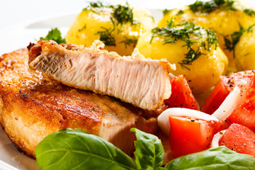 Grilled steaks, boiled potatoes and vegetable salad