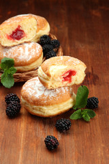 Tasty donuts with berries on wooden table
