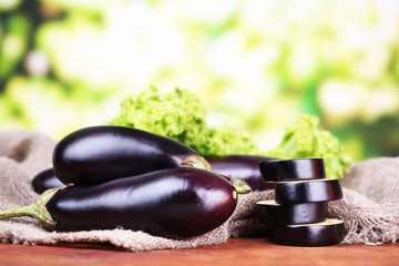 Fresh eggplants on table on bright background