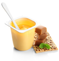 Tasty yogurt in open plastic cup, cookies and toffee candies
