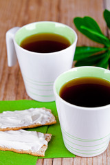 two cups of tea and crackers with cream cheese