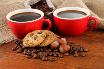 Red cups of strong coffee with coffee beans and cookies