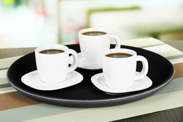 Cups of coffee on tray on table in cafe