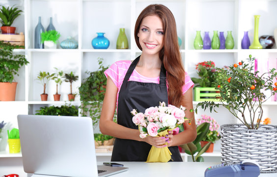 Beautiful girl florist with flowers in flowers shop
