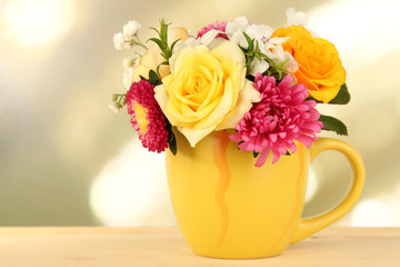 Beautiful bouquet of bright flowers in color mug,