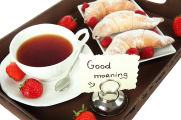 Cup of tea with cakes on wooden tray close-up