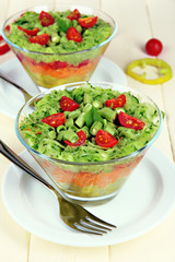Tasty salad with fresh vegetables on wooden table
