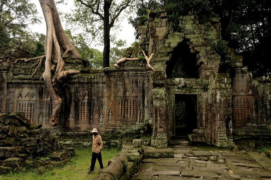 angkor - prheah khan temple, man walks through the ruins