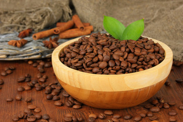 Coffee beans in bowl on wooden background