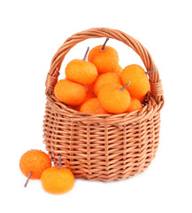 Small tangerines in wicker basket, isolated on white