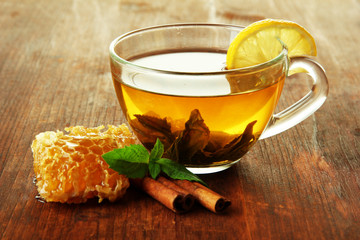 Transparent cup of green tea with honey and cinnamon