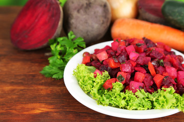 Beet salad on plate on wooden table