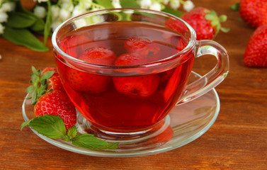 Delicious strawberry tea on table close-up