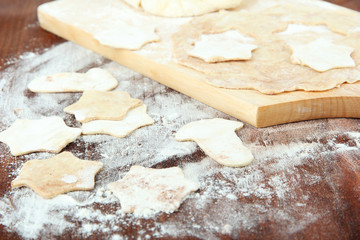 Dough for Christmas cookies on wooden board on table