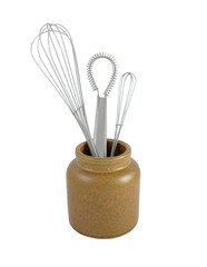 Three metal whisks in a brown ceramic jar