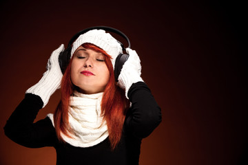 Red hair woman with winter outfit listening to music