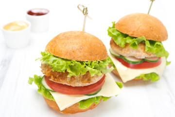 chicken burger with vegetables, cheese and sauces, closeup